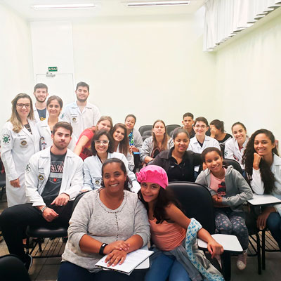 Foto em uma sala com alunos e pacientes da turma da Christine