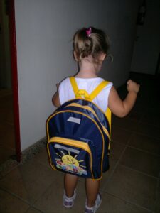 Livia pequena, de costas, com a mochila da creche, no ano do diagnóstico de diabetes tipo 1